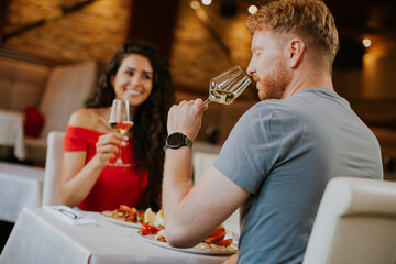 Young couple having lunch with white wine in the restaurant
