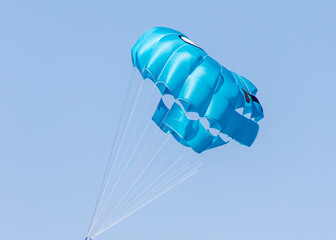 The parachute is flying in the blue sky.