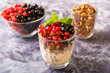 Granola and fresh berries in a glass bowl on the table. Black and red currant with granola.