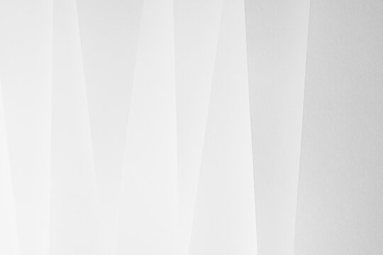 White abstract geometric background with soft light paper inclined vertical lines or surfaces with gradient as pattern. Simple elegant modern backdrop in minimal style.