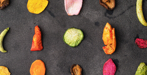 Dehydrated vegan chips crisps in wooden mango bowl. Vitamin salty free healthy fast food with carrot slices, beetroot wedges, broccoli, zucchini on a light table. food photo banner copy space top view