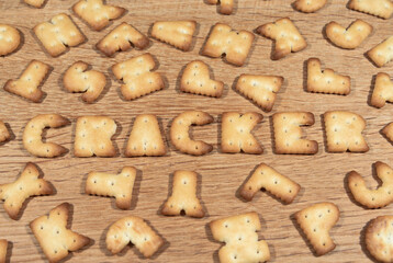 Cracker cookies in the shape of the letters on a wooden surface