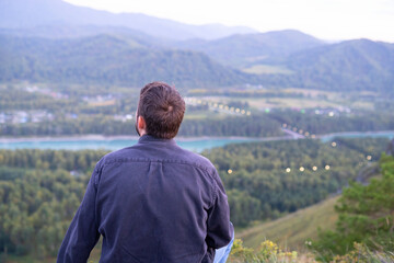 Naklejka premium view from the top of the mountain. a man looks at nature from the mountain. mountain trip