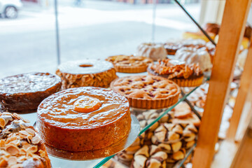 Traditional European bakery shop interior, cake pastry and bread window display, pie, chocolate biscuit cookie, almond bread