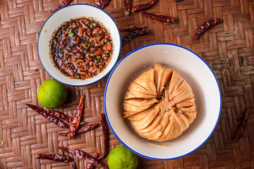 Seasonal food of Thailand. Santol with spicy sauce on the wooden background.