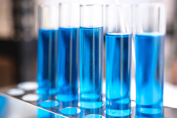 blue chemical liquid experiment in scientific glassware equipment in science medicine laboratory, chemistry or biology research discovery by using glass of test tube or beaker and flask