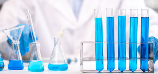 blue chemical liquid experiment in scientific glassware equipment in science medicine laboratory, chemistry or biology research discovery by using glass of test tube or beaker and flask