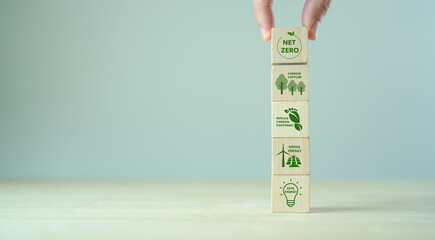 Net zero action concept. Save energy, green energy, reduce carbon footprint, carbon capture. Climate neutral long term strategy. Limit  global warming. Putting wooden cubes with green net zero icon