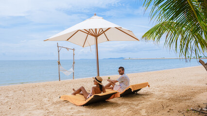 Men and women on the beach are relaxing in a beach chair on a sunny day with a hammock in Pattaya...