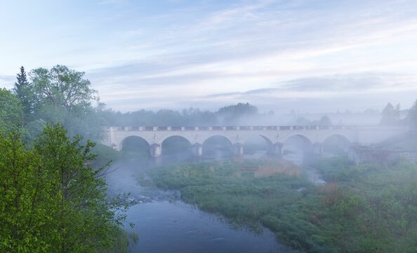 Beautiful shot of an arched bridge over a misty river in Rapla, Estonia