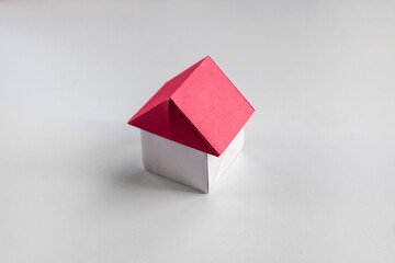 White and red paper house origami isolated on blank background