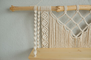Macrame wooden shelf hanging on the wall