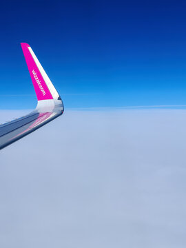 Malmo, Sweden - August 22, 2022: Left wing of WizzAir airplane after taking off above Malmo Sturup airport heading to Belgrade, Serbia