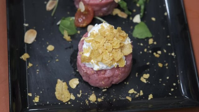 Preparation of meat tartare by a professional chaf in an Italian restaurant kitchen