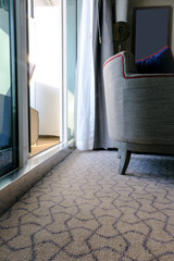Entry hallway corridor living room of suite stateroom cabin with mirror, lights, cupboards, armchairs and flower decoration onboard ocean liner cruiseship cruise ship