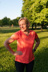 Fototapeta premium Mature blonde woman portrait in park on sunset summer day