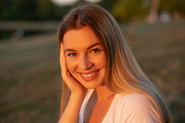 Summer girl portrait. Attractive woman smiling happy on sunny summer or spring day outside in park by lake.