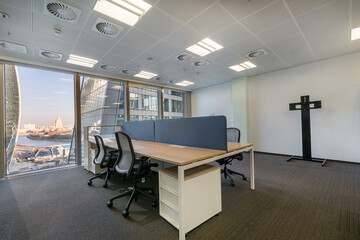 A bright office with gray flooring, furniture and a panoramic window