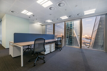 Office space with light walls, gray flooring. View from the panoramic window.