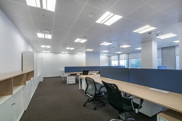 An open space of a bright office with panoramic windows and furniture.