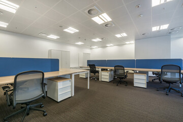 A spacious, bright office room with gray flooring and furniture.