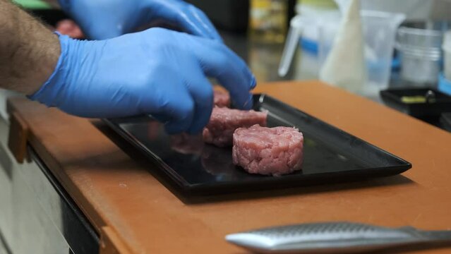 Preparation of meat tartare by a professional chaf in an Italian restaurant kitchen