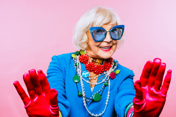 Cool and stylish senior old woman with fashionable clothes - Funny colorful portrait of elderly female lady on colored background - obrazy, fototapety, plakaty
