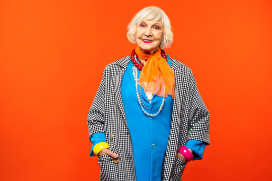 Cool and stylish senior old woman with fashionable clothes - Funny colorful portrait of elderly female lady on colored background