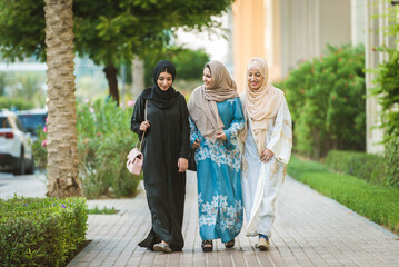 Arabic women wearing traditional abaya dress meeting and having fun in Dubai - Happy beautiful...