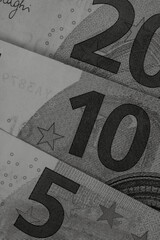 Vertical closeup shot of euro banknotes in grayscale