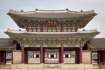 Obraz premium Colorful traditional wood Korean architecture temple gate main entrance at Gyeongbokgung Palace in Seoul South Korea