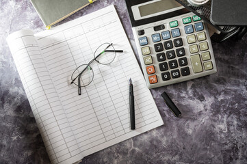 Journal for financial management. Magazine, glasses and calculator on the desktop. Fountain pen and...