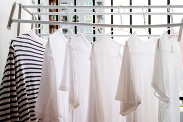 Close up white clothes hang on the clothes rack at the Balcony, White clothes hangers for hanging the wets clothes, laundry, clothes cleaning, housework, Store concept, empty hanger. A place for text.