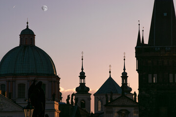 Fototapeta na wymiar Prague silhouettes at dawn with the moon in the sky