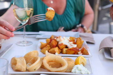 squid rings, lemon juice and potato with garlic sauce aioli and tomato ketchup on square plate