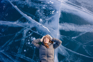 Travel winter Lake Baikal, happy joy woman tourist lie on ice sunset, top view - obrazy, fototapety, plakaty