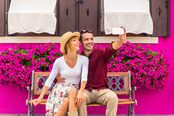 Happy beautiful couple of lovers doing romantic trip in Venice, Italy - Tourists visiting historic town of Venice and Burano island