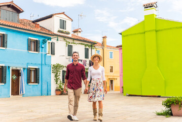 Happy beautiful couple of lovers doing romantic trip in Venice, Italy - Tourists visiting historic town of Venice and Burano island