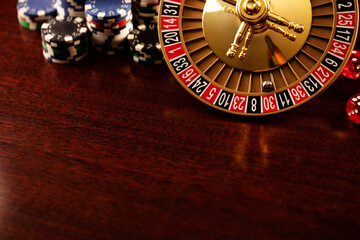Casino. Roulette wheel, dice and poker chips on the bokeh background.