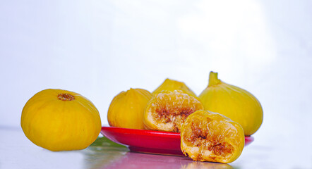 Yellow figs in a red bowl