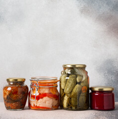 Preserving vegetables for the winter, canned vegetables in jars on a light background, pickled or fermented vegetables, copy space