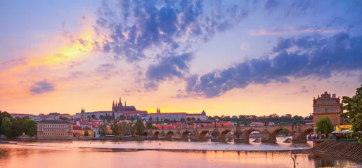 Fotobehang Stadszomerlandschap bij zonsondergang, panorama, banner - uitzicht op de Karelsbrug en het kasteelcomplex Praagse burcht in het historische centrum van Praag, Tsjechië © rustamank