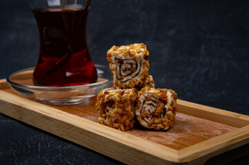 Turkish Delight and Turkish tea in wooden plate on black background