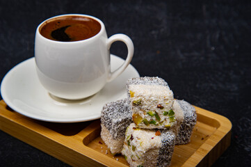 Turkish Delight and Turkish coffee in wooden plate on black background
