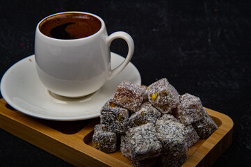 Turkish Delight and Turkish coffee in wooden plate on black background