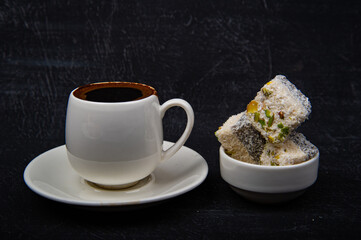 Turkish coffee and Turkish delight on black background.