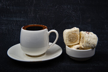 Turkish coffee and Turkish delight on black background.