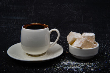 Turkish coffee and Turkish delight on black background.