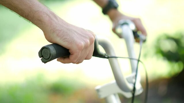cyclist on a bike adjusting the speed on the handlebar of his bicycle, close up of hands on the steering handle of a bicycle, healthy lifestyle, outdoor ride on a bike