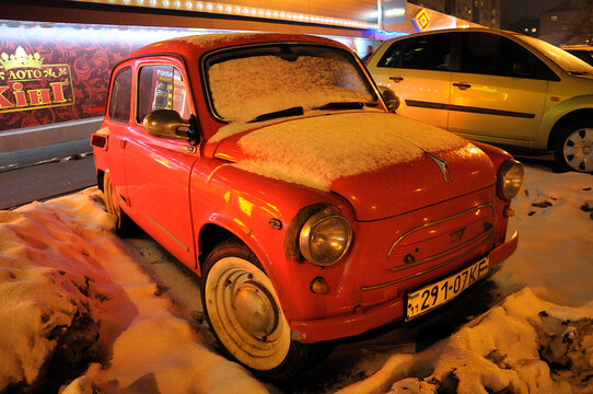Made in USSR an old car ZAZ Zaporozhets abondoned on the street covered with snow. Kyiv, Ukraine